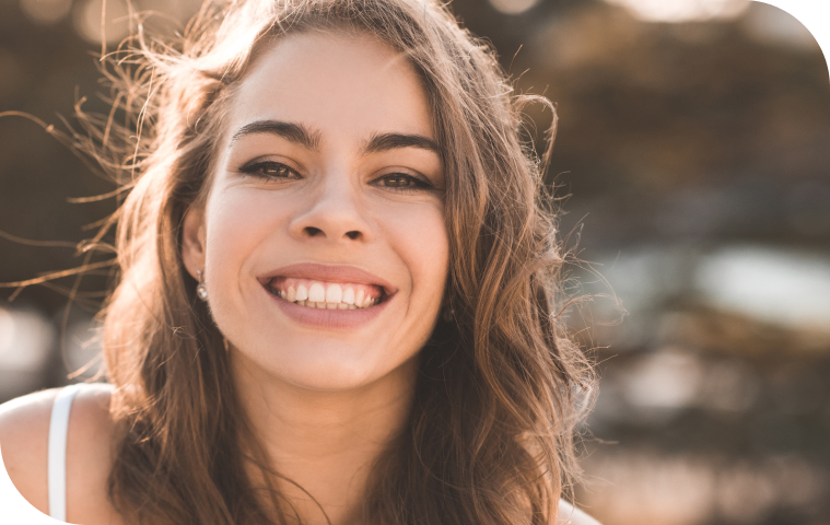 Femme au sourire lumineux suivant les recommandations après éclaircissement, dentiste Douai